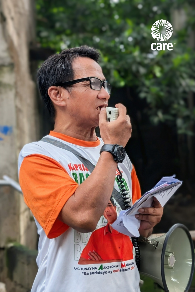 A volunteer disseminates information about dengue and leptospirosis, their health risks, and ways to prevent them through a speaker phone. 