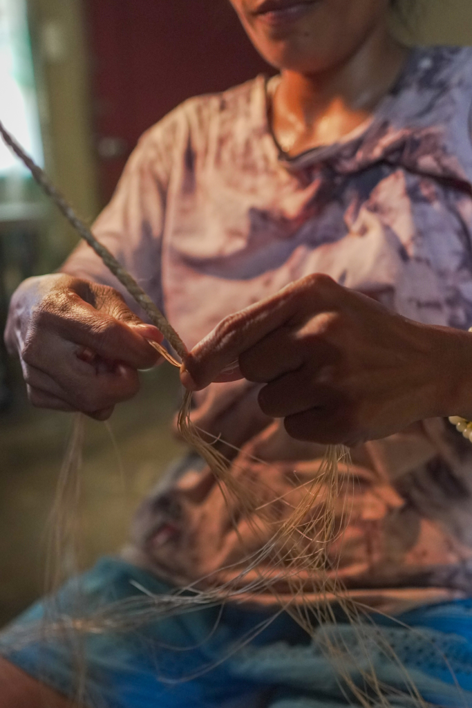 A woman makes a twine out of Manila hemp (abaca) fibers. 